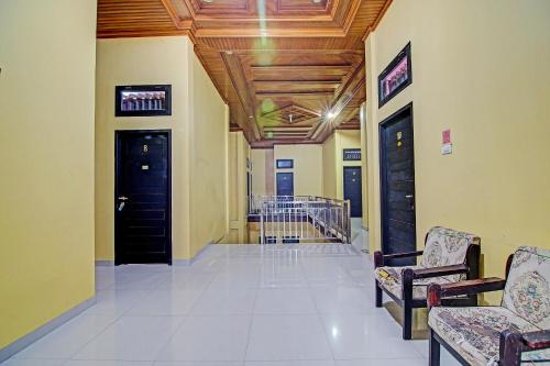 a hallway with two doors and chairs in a building at Hotel O Arafah Homestay Syariah Near Badan Pertanahan Nasional - Kantor Pertanahan Kabupaten Kampa in Bangkinang