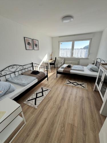a room with two beds and a wooden floor at Marburg 3 Zimmer Wohnung Wiesenweg in Marburg an der Lahn