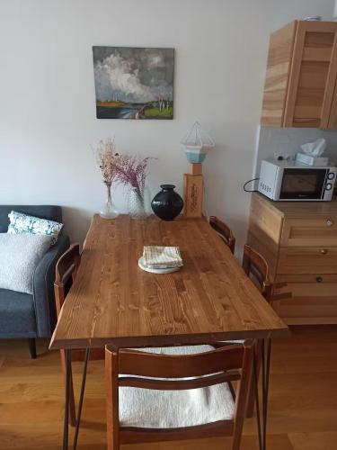 - un salon avec une table en bois et un four micro-ondes dans l'établissement Appartement avec parking, à Paris