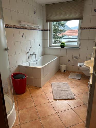 a bathroom with a tub and a toilet and a window at Ferienwohnung Dachstübchen in Bad Lauterberg
