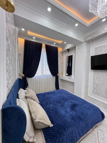 een slaapkamer met een groot blauw bed en een raam bij Аpartment in Samarkand