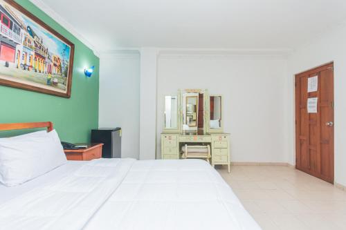 a bedroom with a white bed and a dresser at Hotel Baluarte Cartagena Boutique in Cartagena de Indias