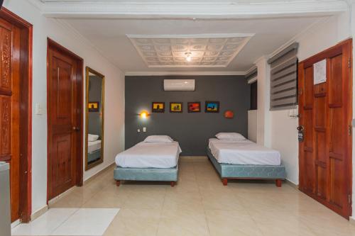two beds in a room with two beds sidx sidx sidx sidx sidx at Hotel Baluarte Cartagena Boutique in Cartagena de Indias