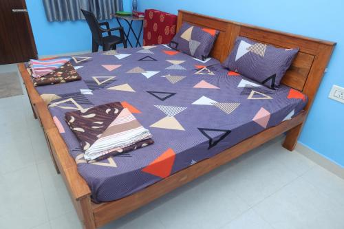 a bed with a blue comforter and pillows on it at Rathna Inn in Vishāram