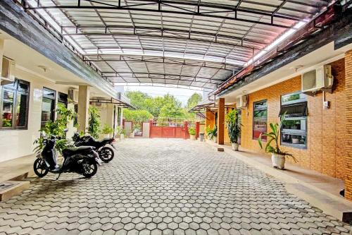 quelques motos garées dans un bâtiment dans l'établissement Hotel O Mariko's House, à Kupang