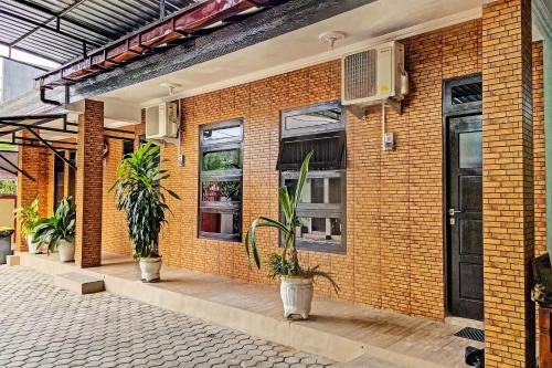 un bâtiment en briques avec des plantes en pot dessus dans l'établissement Hotel O Mariko's House, à Kupang