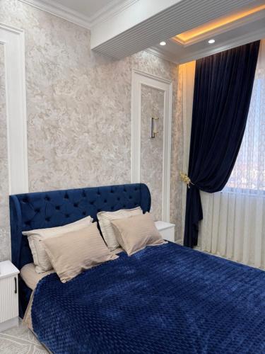 een slaapkamer met een blauw bed en een raam bij Аpartment in Samarkand