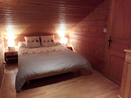 a bedroom with a bed in a wooden wall at Chalet des FURETS in Xonrupt-Longemer