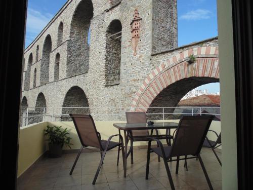 a balcony with a table and chairs in front of a building at The Arch Nest in Kavala
