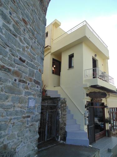 a building with a stone wall and a balcony at The Arch Nest in Kavala