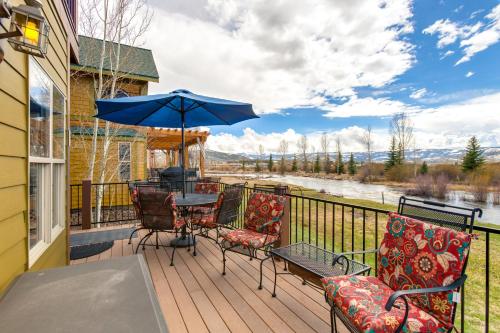 a deck with a table and chairs and an umbrella at Riverfront Cabin 4 Mi to Granby Ranch in Granby