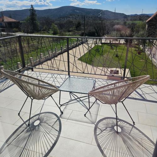 a glass table and two chairs on a balcony at Villa Hirundinidae in Gornji Muć