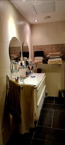 a bathroom with a sink and two mirrors at Chambre double in Limonest