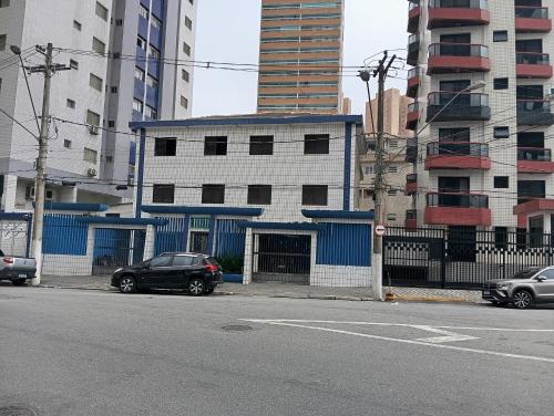 a black car parked on the side of a street with buildings at Apto Boqueirão praia gde in Praia Grande