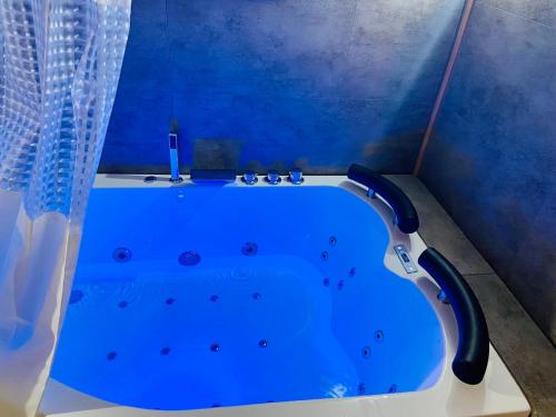 une baignoire bleue dans une pièce bleue dans l'établissement La cabane balnéo vue mer, à Bazenville