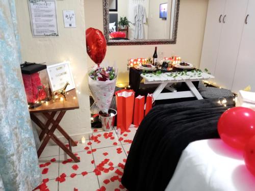 a room with a bed and a table with balloons at Olivia Pines Guesthouse 4 Bedroom Self Catering House in Krugersdorp