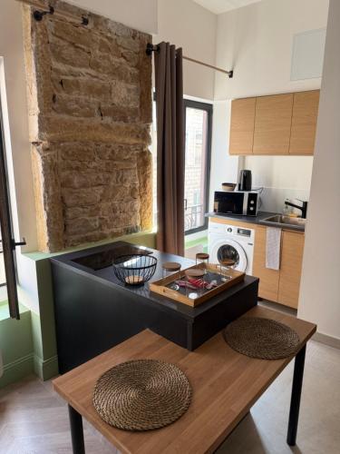 une cuisine avec une table et un comptoir dans l'établissement Appartement élégant et chic refait à neuf, à Lyon