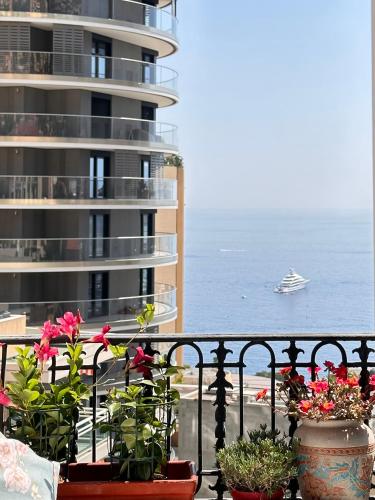 - un balcon fleuri et un bateau de croisière dans l'océan dans l'établissement Luxury Tenao palace, Monaco border, sea view, à Beausoleil