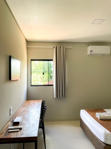 a room with a desk and a bed and a window at Cubo Hotel in Rio Branco