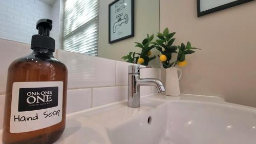 a bottle of hand soap sitting on a bathroom sink at Notting Hill - The One One One -2- in London