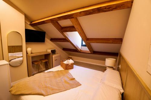 a small attic room with a bed and a window at Vista Verde in Cuenca