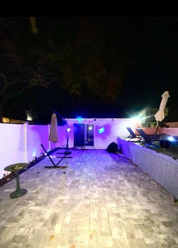 a dark room with purple lights and a stage at Studio guest house in Hempstead