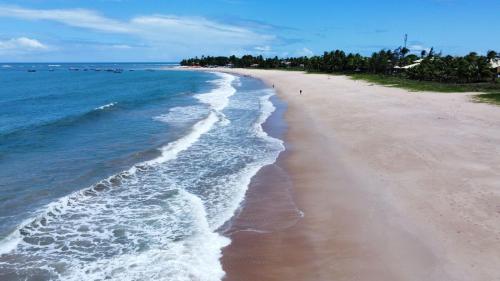 a beach with the ocean and the shoreline at Bioflora Itacimirim Novo village 44 in Camacari