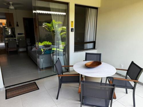 a dining room with a white table and chairs at Bioflora Itacimirim Novo village 44 in Camacari