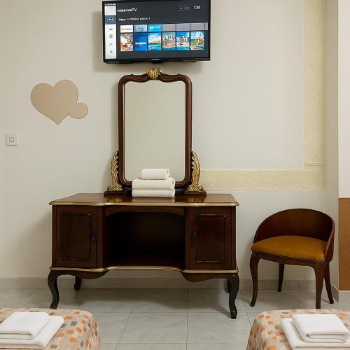 a dresser with a mirror and a tv on a wall at Valletta Door in Il-Furjana