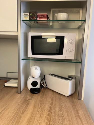 a kitchen with a microwave and a printer on a shelf at Apartamento Levante Playa Torretjó in Benidorm