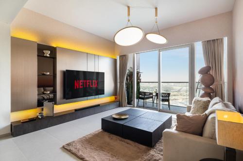 a living room with a couch and a tv at Bella Elite Homes at Grande Signature Amazing Burj and Fountain View-Brand New Luxury Apartment in Dubai