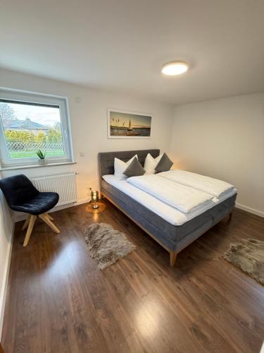 a bedroom with a bed and a chair and a window at Wildpark Perle in Bad Harzburg