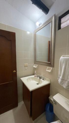 a bathroom with a sink and a mirror and a toilet at El Rincón De La Abuela Paisaje y Confort in La Cumbre