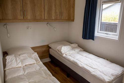 ホルステブローにあるHolstebro Søparkの窓のある小さな部屋にベッドが2つある