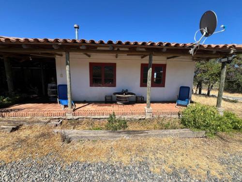 a house with two blue chairs on a patio at Casa Bagual in Calivoro
