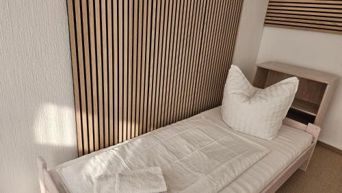 a bed with a white pillow in a room at City-Pension-Bautzen in Bautzen