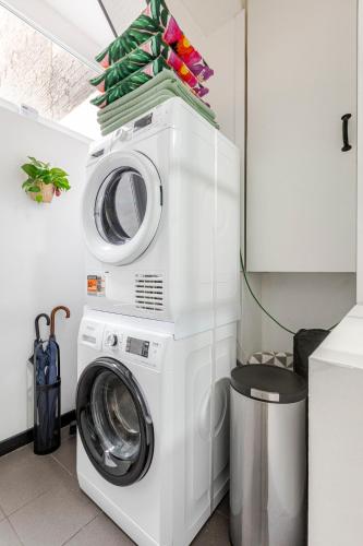 a washer and dryer in a kitchen with at Cosy appartement met tuin in centrum Antwerpen Gratis parking Free Parking! in Antwerp