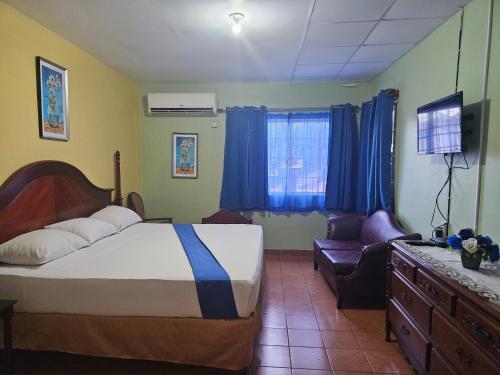 a bedroom with a bed and a couch and a television at Palm Bay Guest House & Restaurant in Montego Bay
