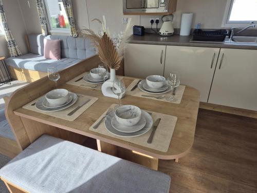 a table with plates and glasses on it in a kitchen at Jan' Sea View Getaway in Heysham