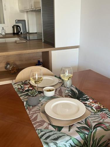 a table with two plates and two glasses of wine at Apartamento Levante Playa Torretjó in Benidorm
