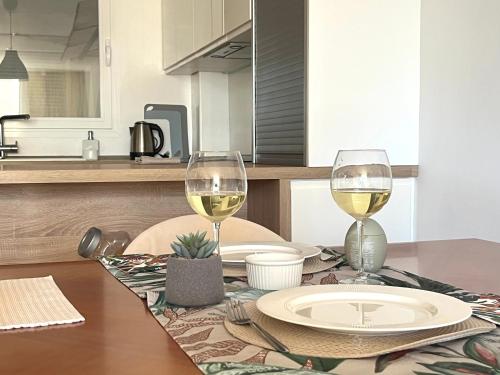 a table with two glasses of white wine on it at Apartamento Levante Playa Torretjó in Benidorm