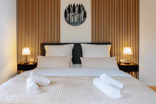 a bedroom with a bed with two white towels on it at Marktplatz-Flair mit Dachterrasse im Zentrum in Freudenstadt