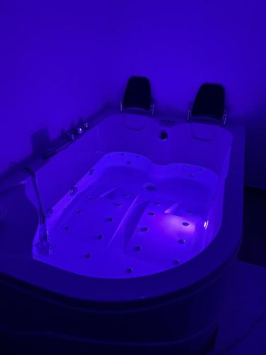 a purple room with a tub with two chairs in it at Bio B&B La Scoperta del Pollino in Laino Castello