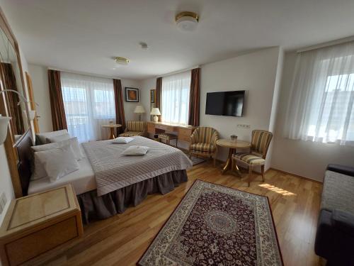 a hotel room with a bed and a living room at Villa Katharina in Rust