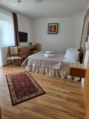 a bedroom with a bed and a desk and a rug at Villa Katharina in Rust