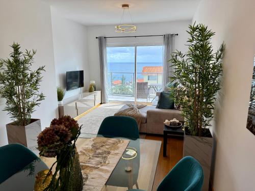 a living room with a couch and a table with plants at Welcome to Paradise Island in Caniço