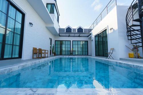 a swimming pool with blue water in a house at Queenstown Khaoyai in Pak Chong