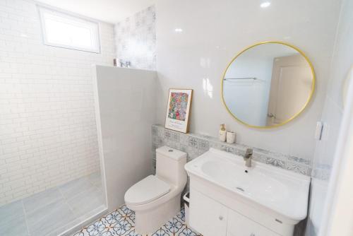 a bathroom with a toilet and a sink and a mirror at Queenstown Khaoyai in Pak Chong