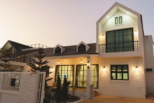 a large white house with a lot of windows at Queenstown Khaoyai in Pak Chong