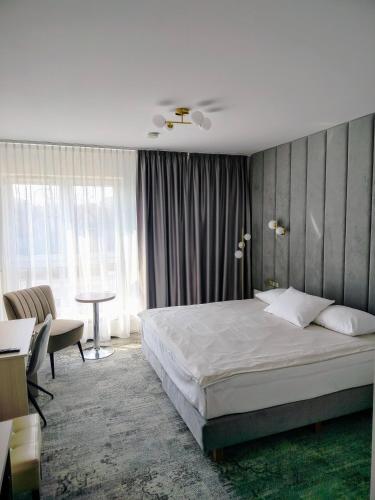 a bedroom with a bed and a desk and a table at Hotel Sokołowska Airport Modlin in Nowy Dwór Mazowiecki